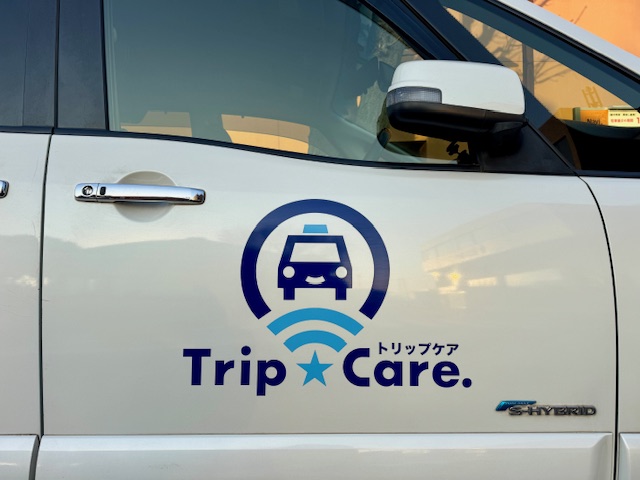 福祉介護タクシー　トリップケアのロゴが入った車両ドアサイド