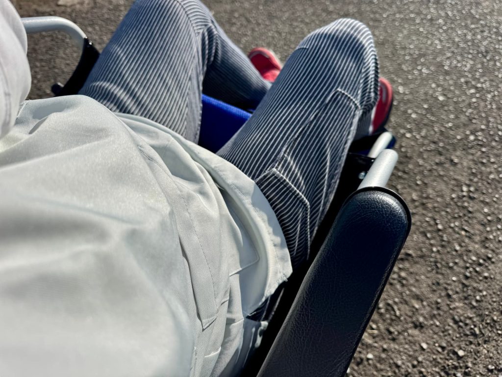 実際に人を乗せて安全姿勢を確認しながら階段介助を学ぶ新人スタッフ