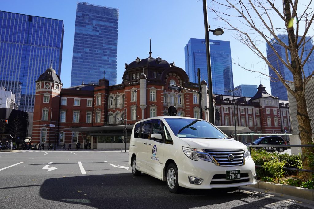 東京駅でのロゴマークの入った福祉介護タクシー車両