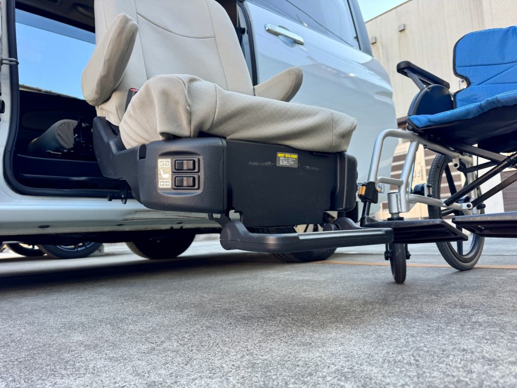 スライドシートが地面近くまで降りた福祉介護タクシー車両