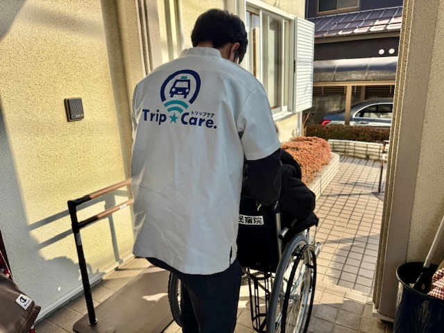 町田市のご自宅前で、車いす利用者様を丁寧に介助する福祉介護タクシーのスタッフ