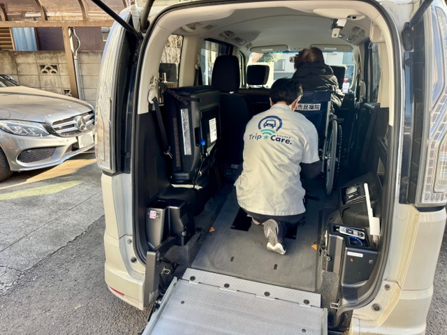 車いすを安全に固定し、乗車準備を行う福祉介護タクシー Trip☆Care. のスタッフ