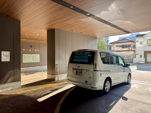 あけぼの病院前で透析通院送迎を行う福祉介護タクシー Trip☆Care. の車両
