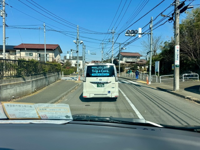 スタッフが運行する福祉介護タクシー車両が目の前を走っている