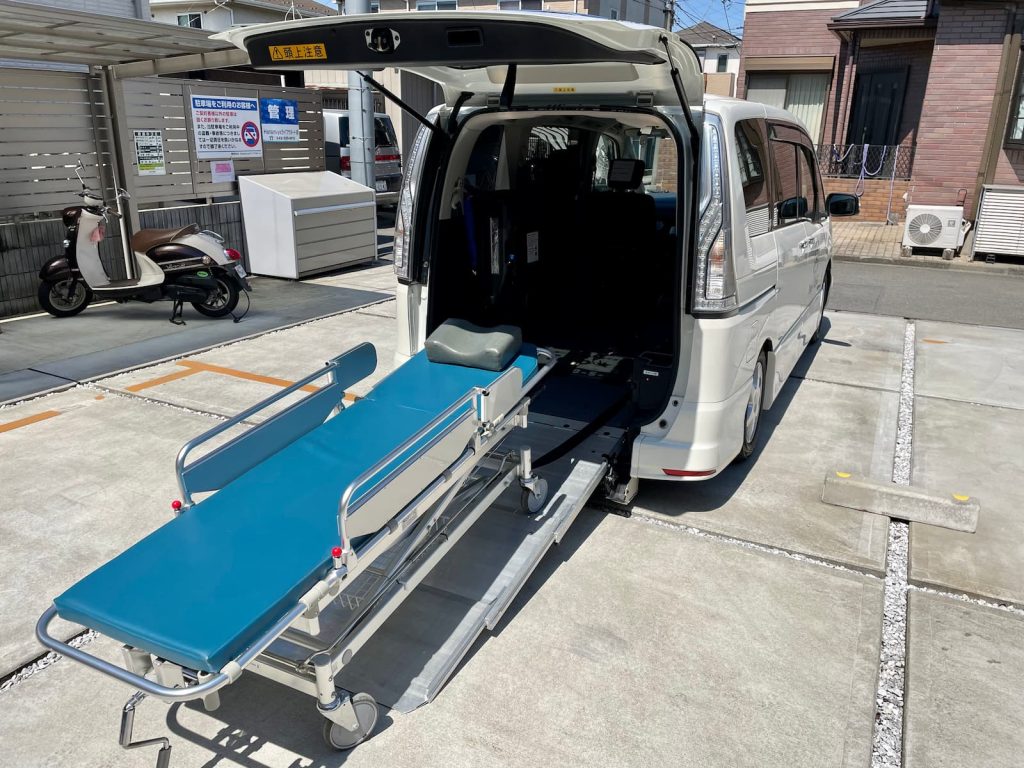 福祉介護タクシー車両（スロープ車両）にストレッチャーを乗せる様子