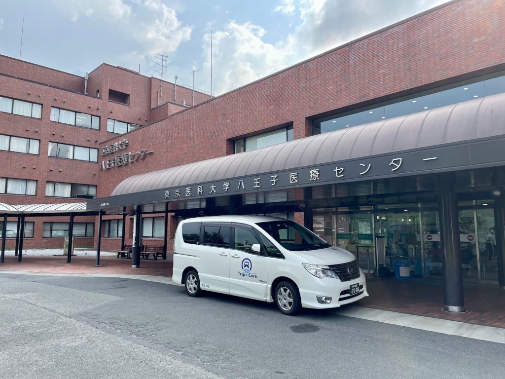 八王子市の東京医科大学八王子医療センターの外観と福祉介護タクシー車両