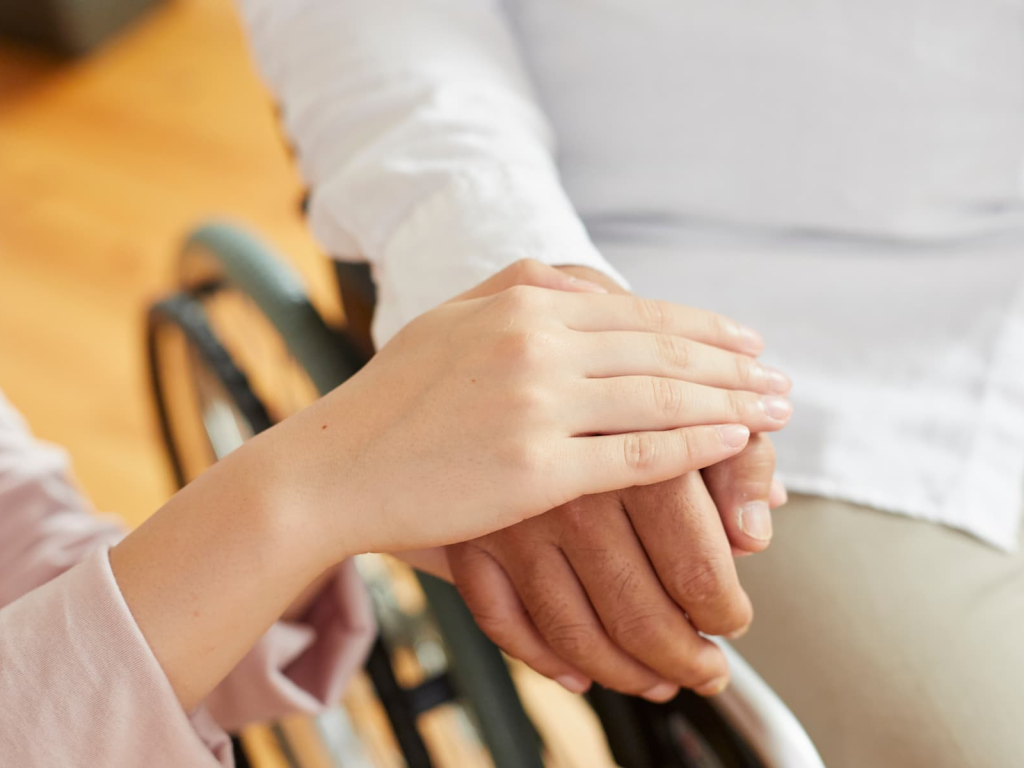 スタッフが車いすの患者さんに手を添えている様子