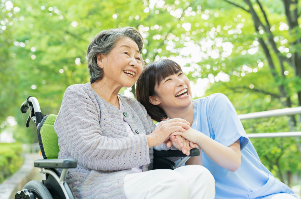 車いすに乗ったシニアとヘルパーが公園を楽しむ様子