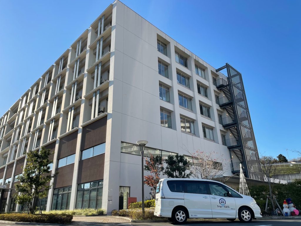 座間市の座間総合病院の外観と福祉介護タクシー車両