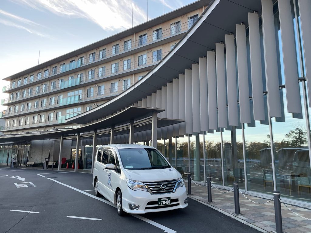川崎市麻生区の新百合ヶ丘総合病院の外観と福祉介護タクシー車両