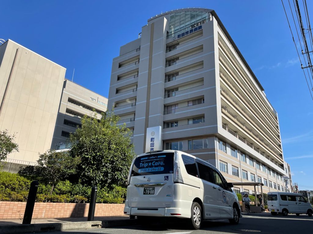 町田市旭町にある町田市民病院の外観と福祉介護タクシー車両