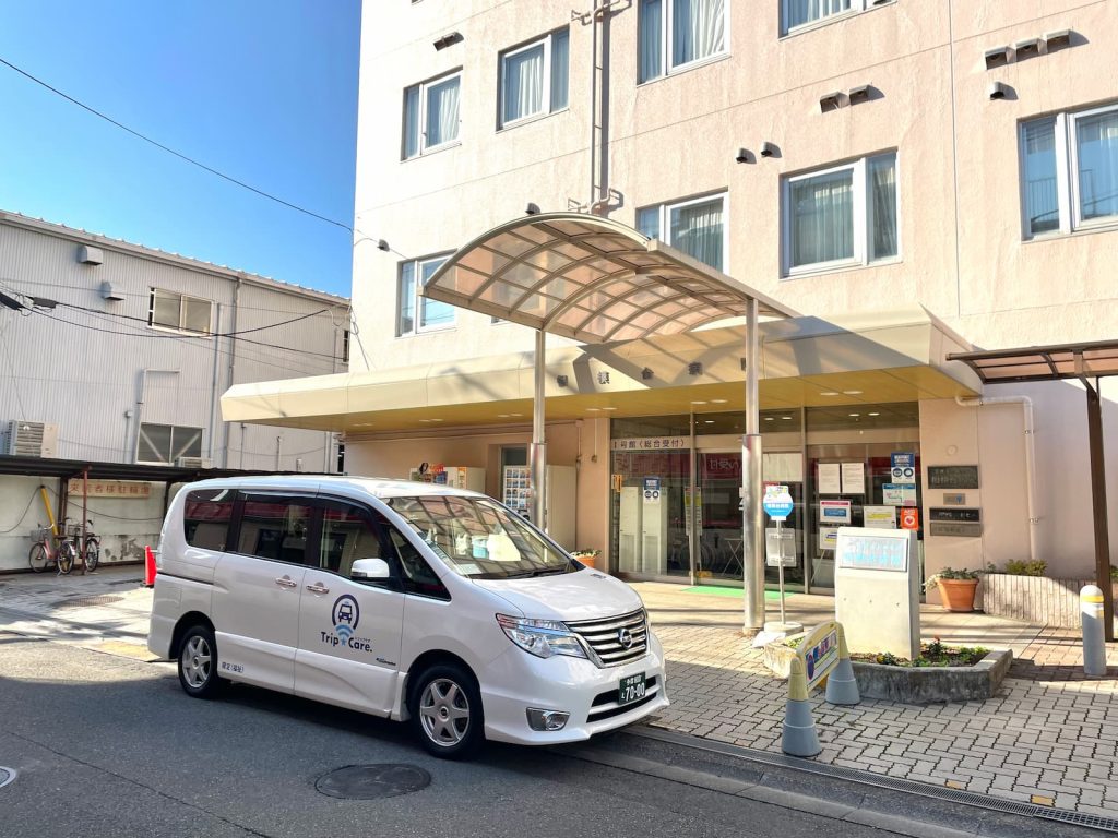 座間市の相模台病院の外観と福祉介護タクシー車両