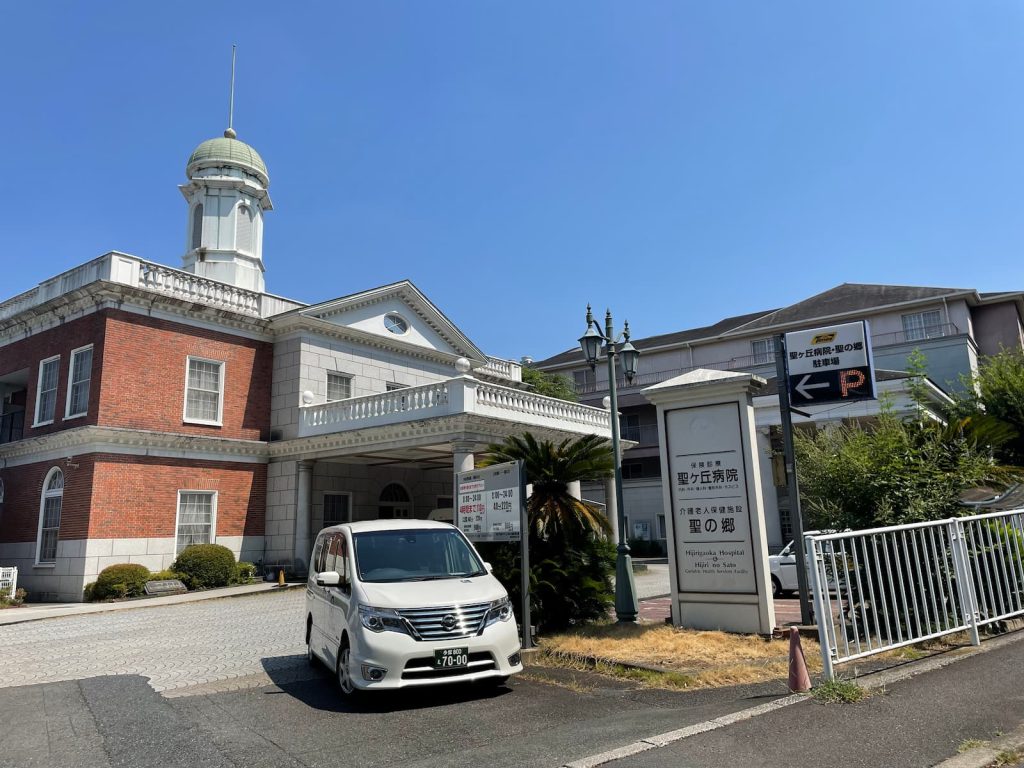 多摩市の聖ヶ丘病院の外観と福祉介護タクシー車両