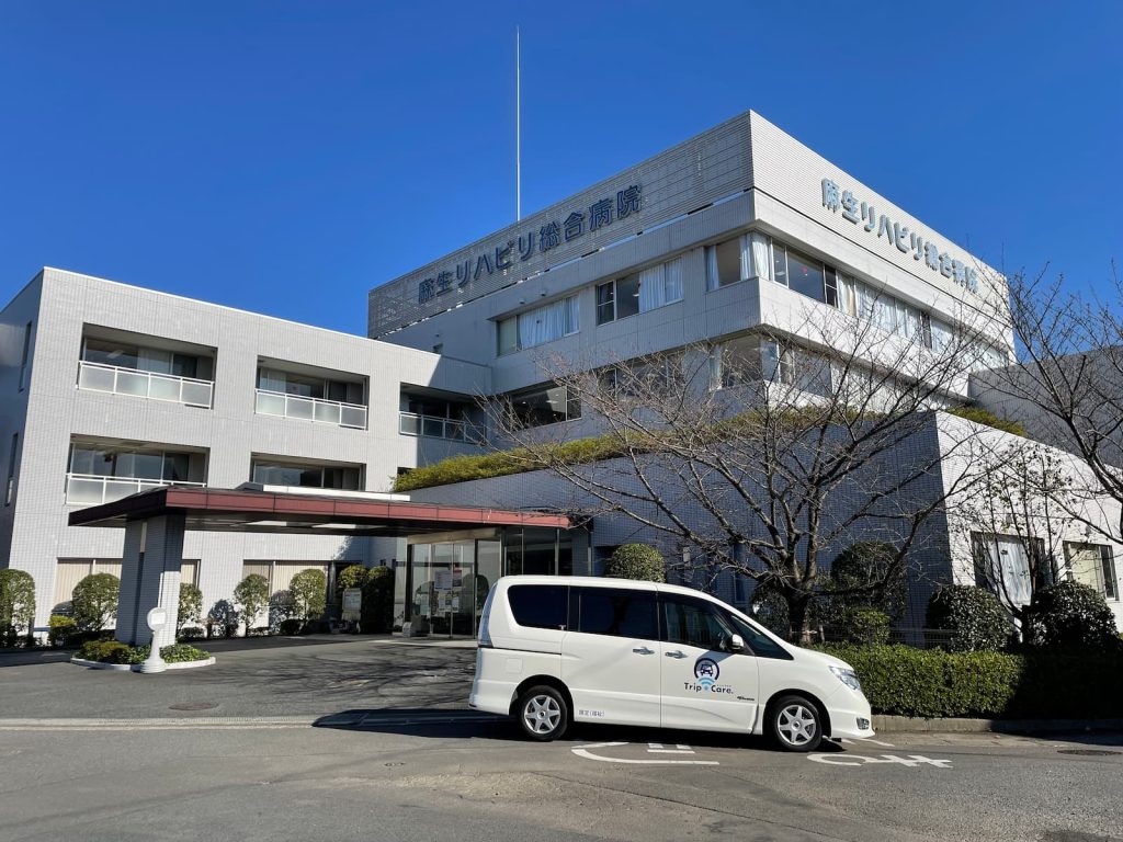 川崎市麻生区の麻生リハビリ総合病院の外観と福祉介護タクシー車両