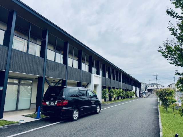 グランハート透析クリニックの外観と福祉介護タクシー車両