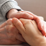 手を握り合い高齢者に安心感を与える